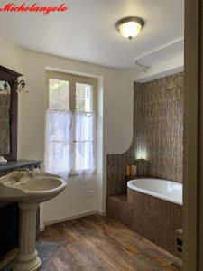 een badkamer met een wastafel en een bad bij Clos Lussault - 4 gîtes, separate or together in Lussault-sur-Loire