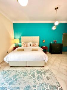 a bedroom with a large bed with a blue wall at DARÏ in Dubai
