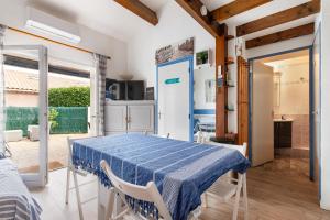 eine Küche und ein Esszimmer mit einem Tisch und Stühlen in der Unterkunft La Casa di Benedetta - 2min à pied de la plage in Portiragnes
