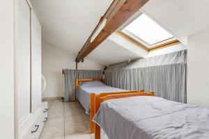 2 Betten in einem kleinen Zimmer mit Dachfenster in der Unterkunft La Casa di Benedetta - 2min à pied de la plage in Portiragnes