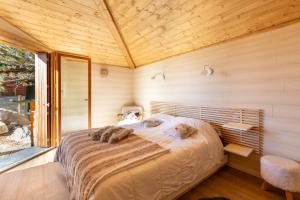 a bedroom with a large bed in a wooden room at Chalet Les Tilleuls - Jolie vue montagne et lac in Les Angles