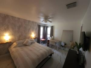 1 dormitorio con 1 cama y ventilador de techo en Charming Home Away From Home, en Fort Lauderdale