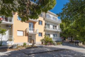 an apartment building with balconies and trees at Apartments by the sea Duce, Omis - 946 in Duće