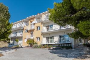 apartamentowiec z balkonami i drzewami w obiekcie Apartments by the sea Duce, Omis - 946 w Duće