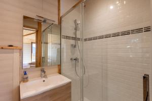 a bathroom with a sink and a glass shower at Chalet Les Tilleuls - Jolie vue montagne et lac in Les Angles