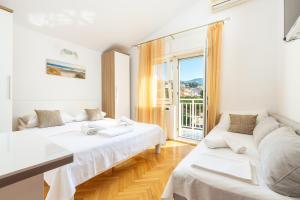 biały pokój z 2 łóżkami i kanapą w obiekcie Apartments by the sea Duce, Omis - 946 w Duće