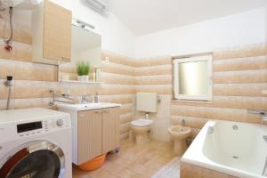 łazienka z pralką, umywalką i toaletą w obiekcie Apartments by the sea Duce, Omis - 946 w Duće
