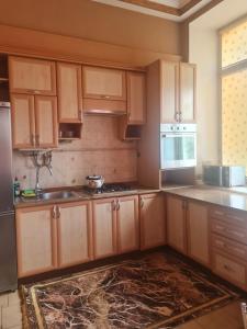 a kitchen with wooden cabinets and a stove top oven at Центр, Євгена Коновальця, 3 in Lutsk