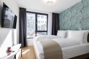 ein Schlafzimmer mit einem großen Bett und einem Fenster in der Unterkunft The Doorman Goethe Frankfurt am Main in Frankfurt am Main