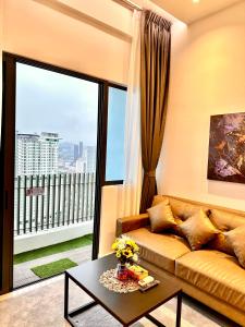 uma sala de estar com um sofá e uma grande janela em The Luxe Colony KLCC BY Infinitum em Kuala Lumpur