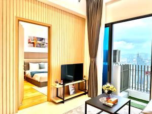 uma sala de estar com uma cama, uma televisão e uma varanda em The Luxe Colony KLCC BY Infinitum em Kuala Lumpur