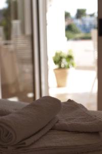 une pile de serviettes assises au-dessus d'un lit dans l'établissement Bozikis House! A cosy apartment in the city centre, à Skiathos Chora