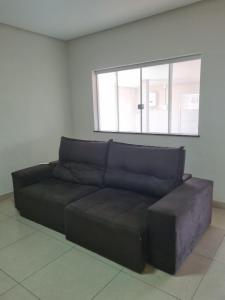 a black couch in a room with a window at Casa de temporada in Piauí