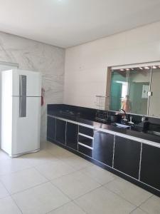 a kitchen with a white refrigerator and a mirror at Casa de temporada in Piauí