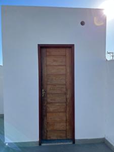 Casa nova - Praia Linda, São Pedro da Aldeia في إيغوابا غراندي: باب خشبي في غرفة ذات جدار أبيض