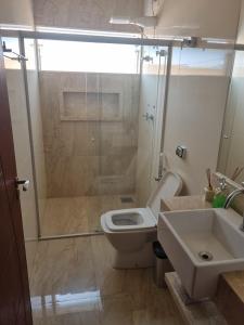 a bathroom with a shower and a toilet and a sink at Casa de temporada in Piumhi