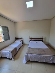 two beds sitting in a room with at Casa de temporada in Piauí