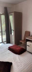 almohada roja sentada en una cama en un dormitorio en Pensiunea Vila Geany SRL, en Băile Herculane