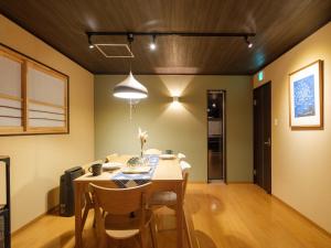 ein Esszimmer mit einem Holztisch und Stühlen in der Unterkunft Muji Arashiyama Villa 無時嵐1階2階賃貸し 駅まで徒歩2分 in Kyoto