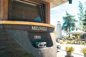 a wood fired restaurant with a sign that says meerkats at Viesu nams Melnsils in Melnsils