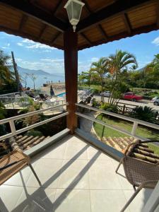 uma varanda com cadeiras e vista para a praia em Pousada Bonns Ventos em Ilhabela