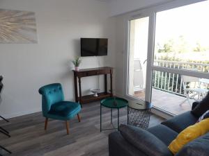 a living room with a couch and a television at Charmant T2 tout confort Cabourg in Cabourg