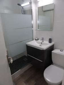 La salle de bains est pourvue de toilettes blanches et d'un lavabo. dans l'établissement Charmant T2 tout confort Cabourg, à Cabourg