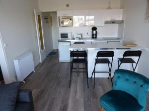 a kitchen with four chairs and a counter top at Charmant T2 tout confort Cabourg in Cabourg