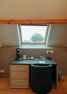 an attic room with a desk and a window at Hotel Ter Zuidhoek in Roeselare