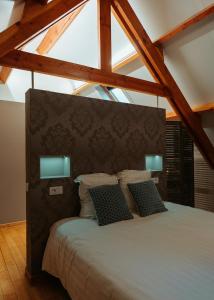 a bedroom with a large bed with two pillows at Hotel Ter Zuidhoek in Roeselare