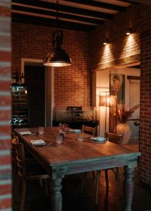 einen Esstisch mit Stühlen und einer zusätzlichen Beleuchtung in der Unterkunft Hotel Ter Zuidhoek in Roeselare