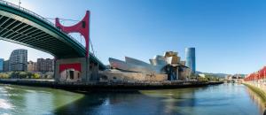 a bridge over a river next to a city at BILBAO DREAMS Luxury in Bilbao
