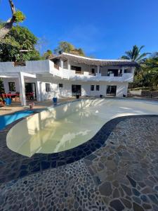 uma piscina em frente a uma casa em Hotel Océan Beach Sakatia em Nosy Be