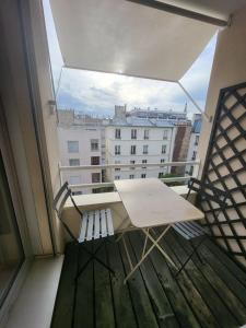 einen Tisch auf einem Balkon mit Blick auf ein Gebäude in der Unterkunft T2 charmant rue de Commerce in Paris