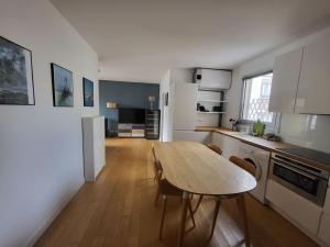 eine Küche mit einem Tisch und Stühlen im Zimmer in der Unterkunft T2 charmant rue de Commerce in Paris