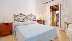 a bedroom with a bed with a blue comforter at VILLA STELLA 6, Emma Villas in Arzachena +31 photos