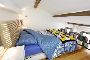 een slaapkamer met een bed met een blauw en geel dekbed bij "Soooo cute !!!!" Up to 6 in Linas