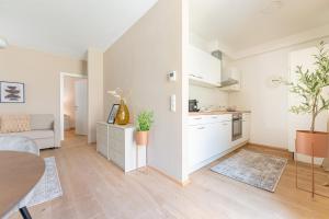 a white apartment with a kitchen and a living room at Garden.Suite am Steinertor in Krems an der Donau