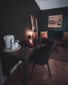 stół z krzesłem i talerz kubków do kawy w obiekcie Hotell Hertig Karl w mieście Filipstad