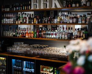 un bar lleno de botellas y vasos en Hotell Hertig Karl en Filipstad