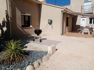 a grill in the courtyard of a house at Maison individuelle plain pied avec Spa en option PENSEZ A VALIDER VOTRE RESERVATION DANS LES 24H APRES VOTRE DEMANDE DE RESERVATION in Perpignan