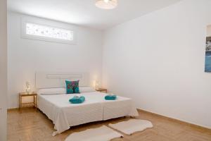 a white bedroom with a bed and a window at Casa Rosi in Tinajo