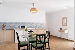 Casa Rosi في تيناجون: مطبخ وغرفة طعام مع طاولة وكراسي