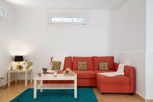 ein Wohnzimmer mit einem roten Sofa und einem Tisch in der Unterkunft Casa Rosi in Tinajo