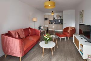 uma sala de estar com um sofá vermelho e uma mesa em DOMITYS LA GALLIQUE em Provins
