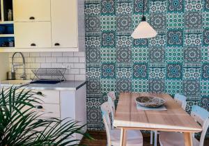 a kitchen with a wooden table with chairs and a green wall at Orient pri hokejovom štadióne in Nivy