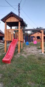 a playground with a red slide in the grass at Casa Giorgiana in Statiunea Borsa