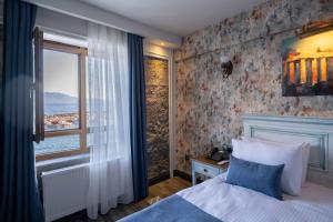 a bedroom with a bed and a window at Assos Troy Port Hotel in Behramkale +36 photos