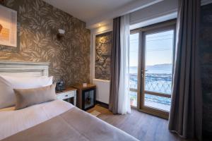 a bedroom with a bed and a large window at ASSOS TROY PORT HOTEL (+8) in Ayvacık