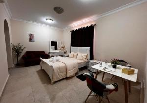 a bedroom with a bed and a table and a couch at Bliss Spot Vacation Homes in Al Ain